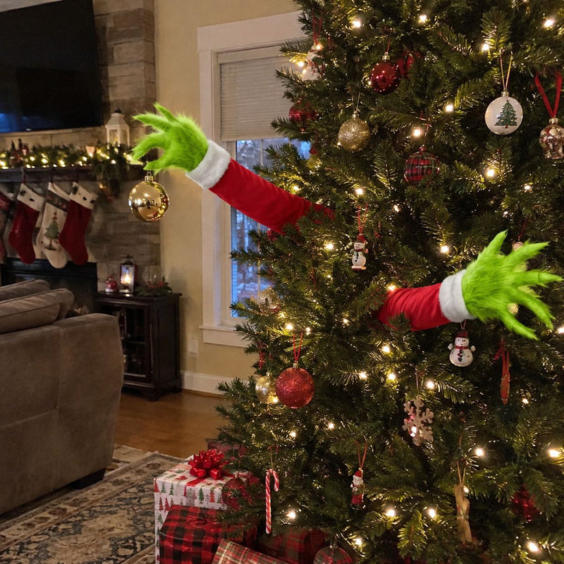 Two furry green arms sticking out of a Christmas tree