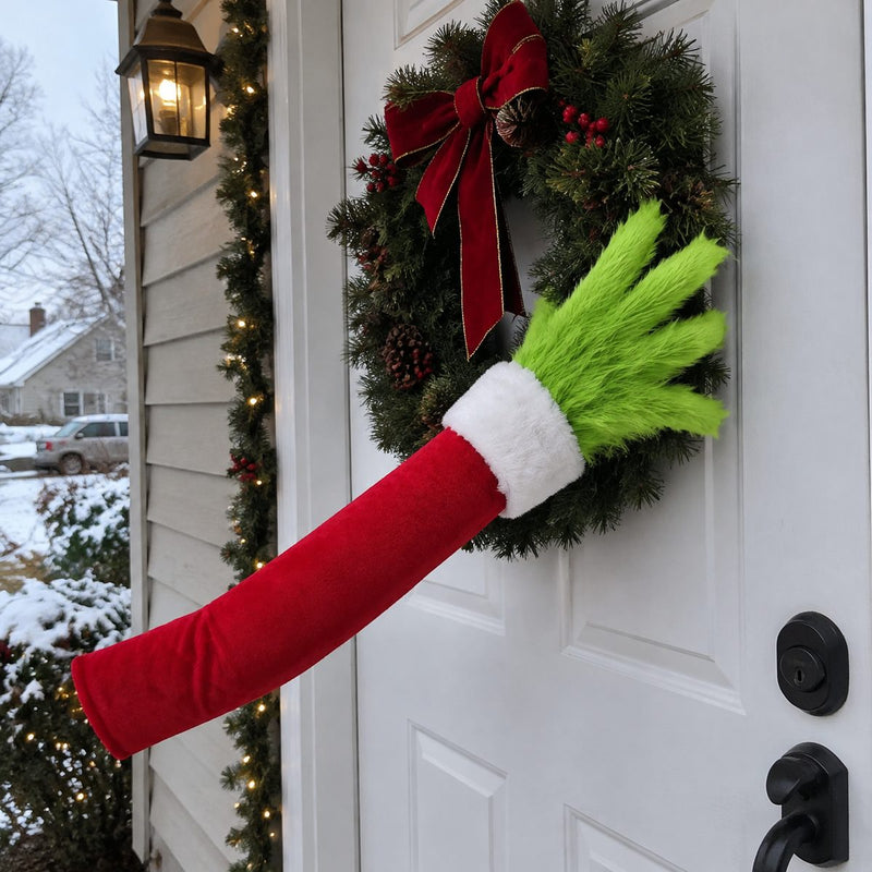 Furry green arm wrapped around a wreath on a front door