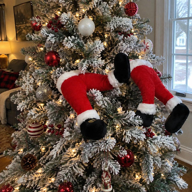 Santa legs poking out of a flocked Christmas tree