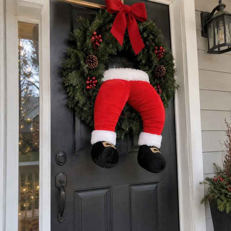 Plush Santa legs stuck in a front door wreath
