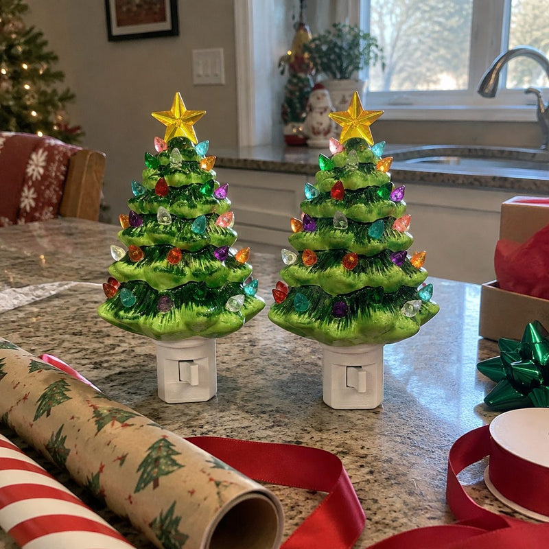 Two ceramic Christmas tree night lights on a counter